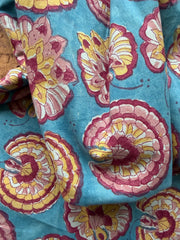 Floral patterned fabric with pink and yellow flowers on a blue background