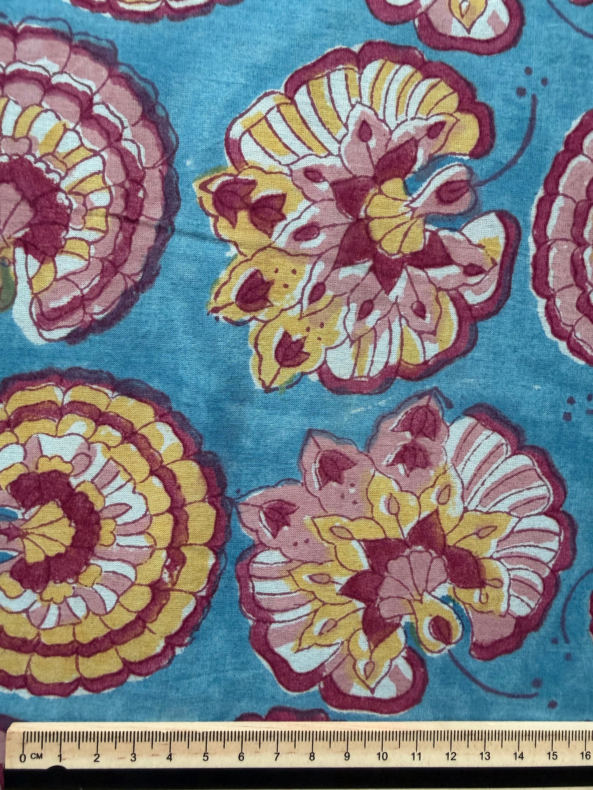 Floral patterned fabric with pink and yellow flowers on a blue background