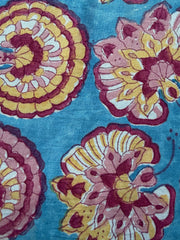 Floral patterned fabric with pink and yellow flowers on a blue background