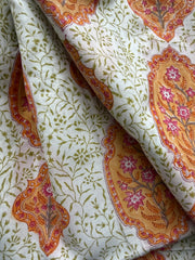 Decorative fabric with floral and leaf patterns in orange, pink, and green on a white background.