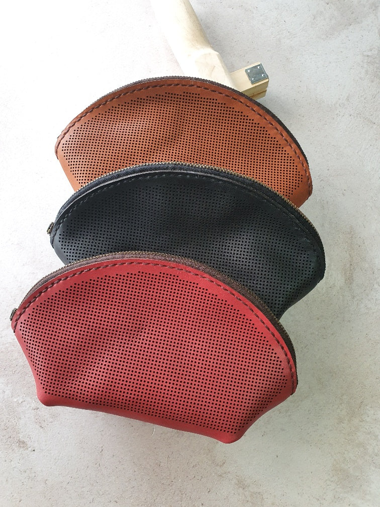 Unstitched cross-stitch leather makeup bags in tan, black and burgundy
