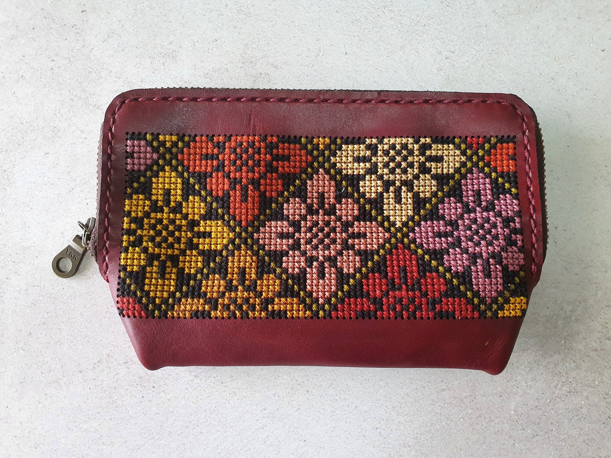 Burgundy leather zipper pouch with pink, yellow and green cross-stitch flowers