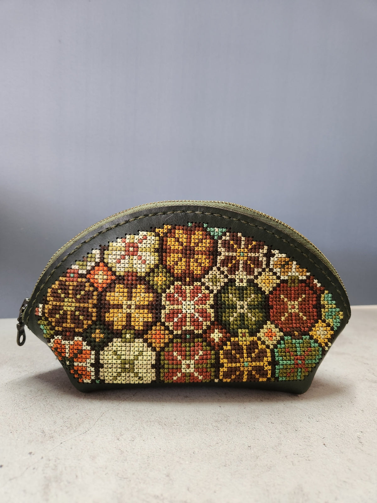 Completed cross-stitch makeup bag with a multicoloured floral pattern
